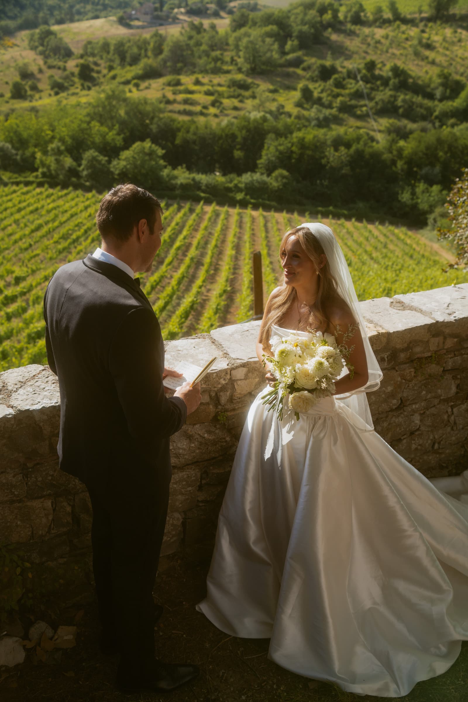 Bride and groom on a vineyard terrace at golden hour, Italy