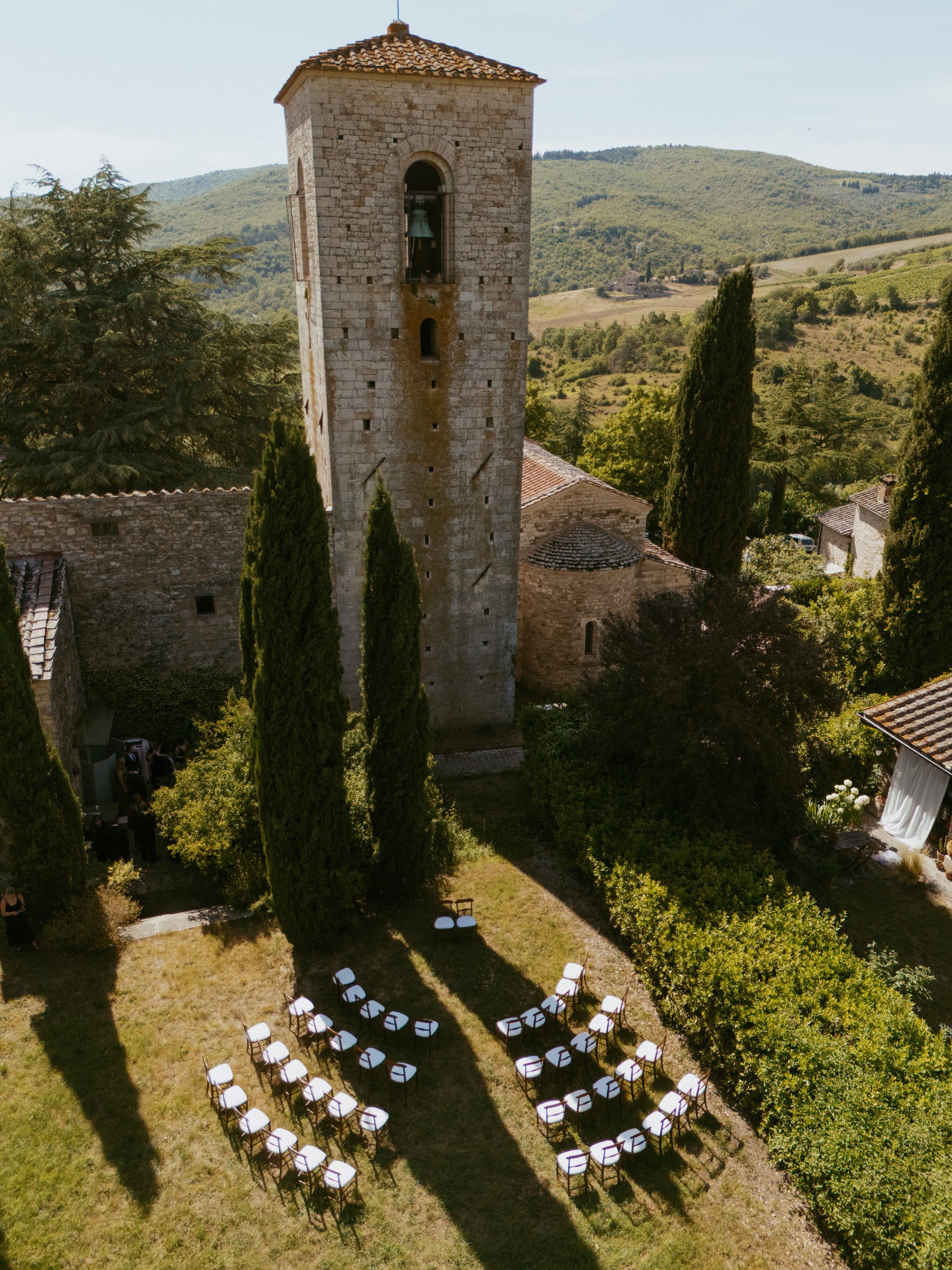 Aerial view of a bell tower and wedding ceremony seating in Tuscany, Italy