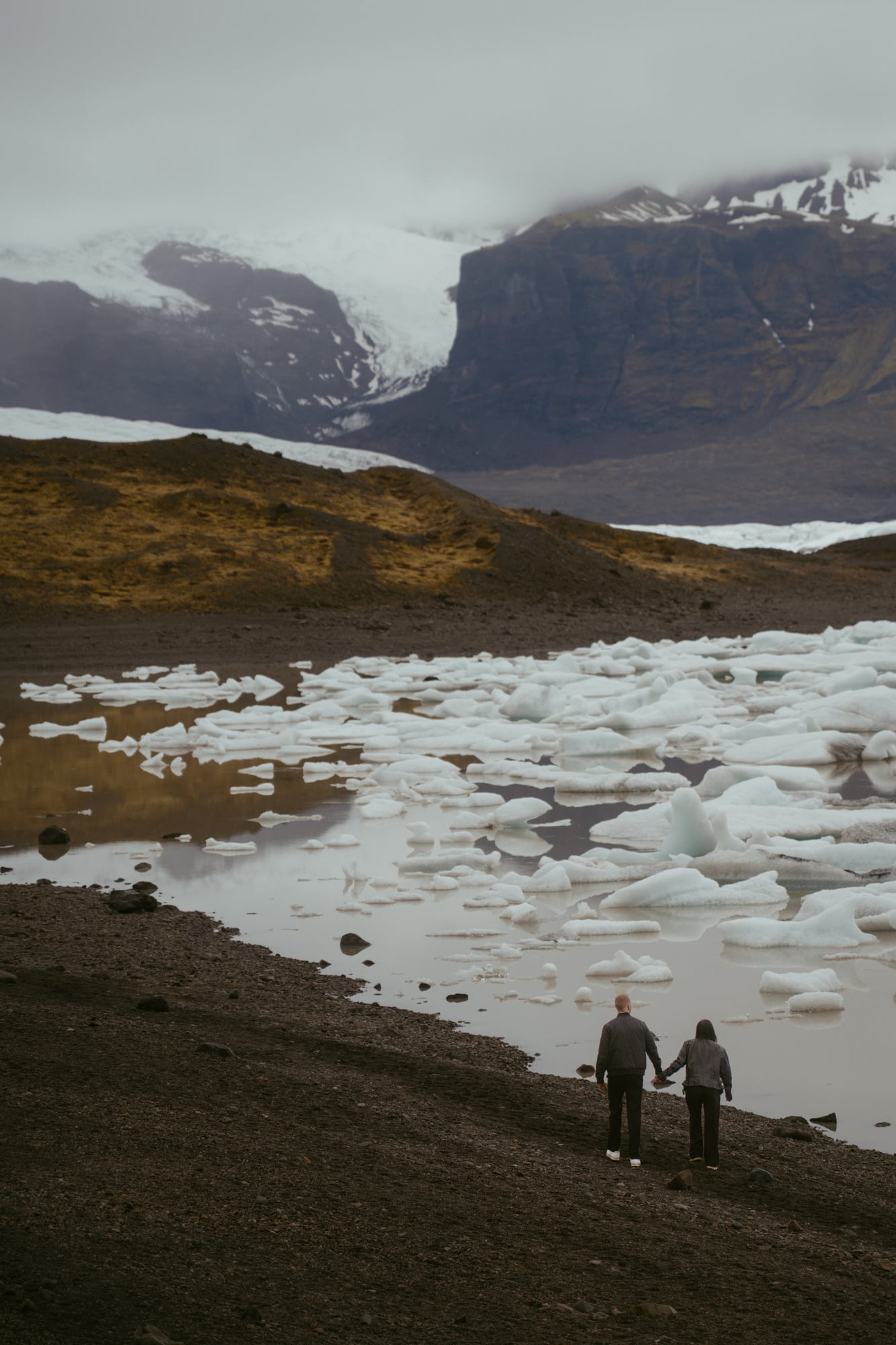 Couple beside a glacier lagoon in Iceland