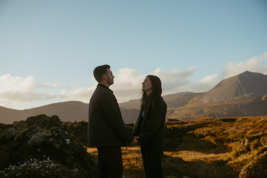 Couple standing in front of the black church in Iceland, Snæfellsnes Peninsula and celebrating their anniversay