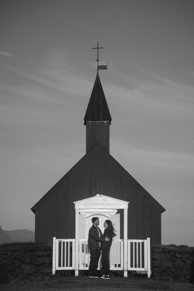 Romantic anniversary moment in front of Búðir’s famous black church on Iceland’s Snæfellsnes Peninsula.