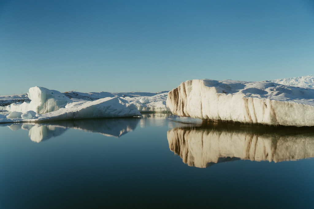 Close-up view of large icebergs reflecting on the still water at Jökulsárlón Glacier Lagoon