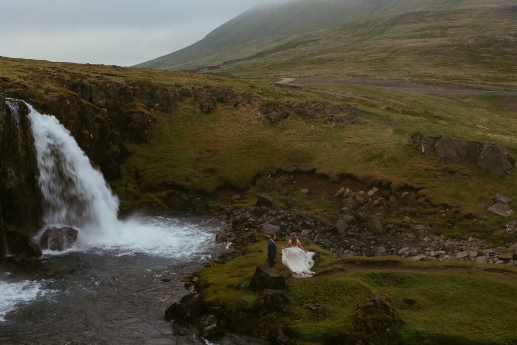 Scenic Iceland wedding portrait at Kirkjufellsfoss with fog and golden light