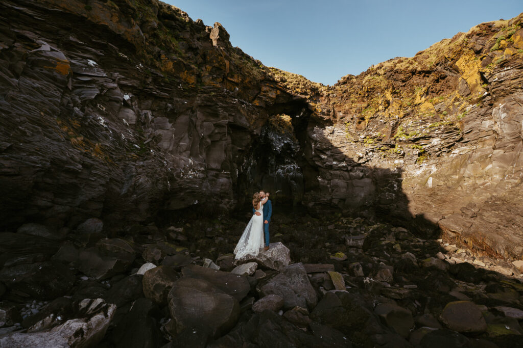 Wide landscape wedding photo near Hellnar coastline in Snæfellsnes