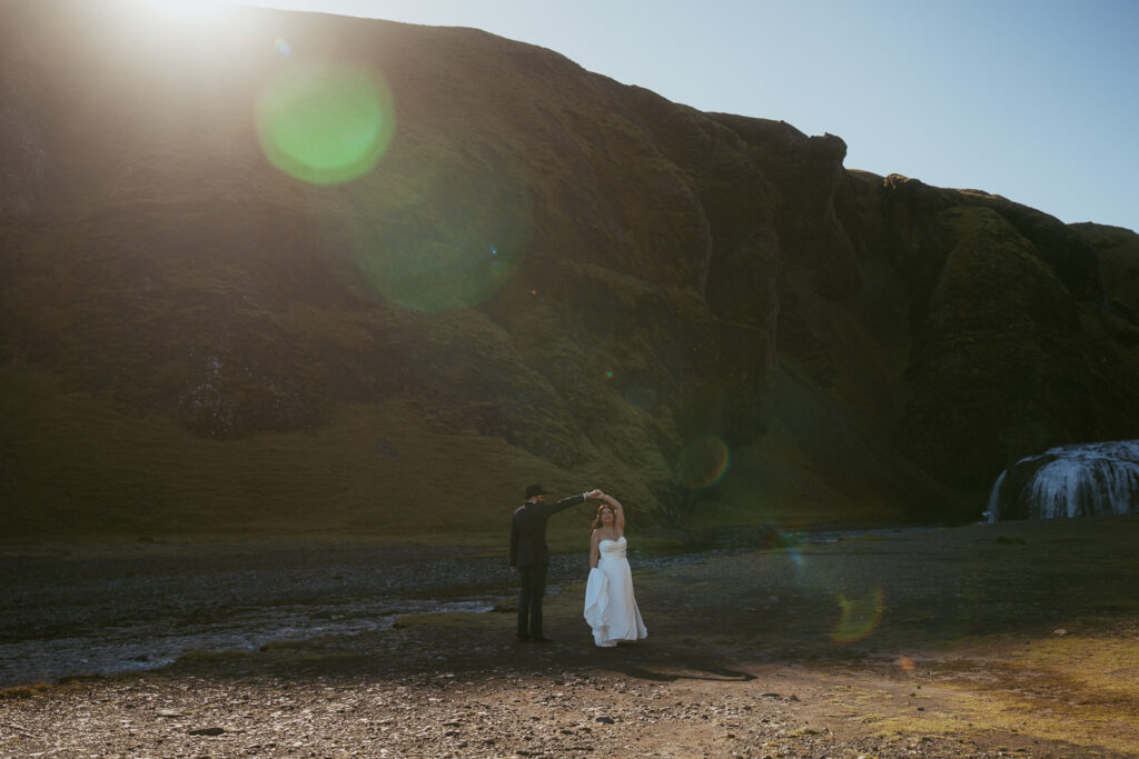iceland elopement, couple standing in front of a waterfall and dancing