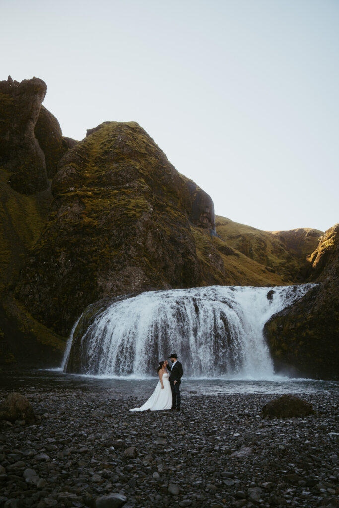 iceland elopement, couple standing in front of a waterfall