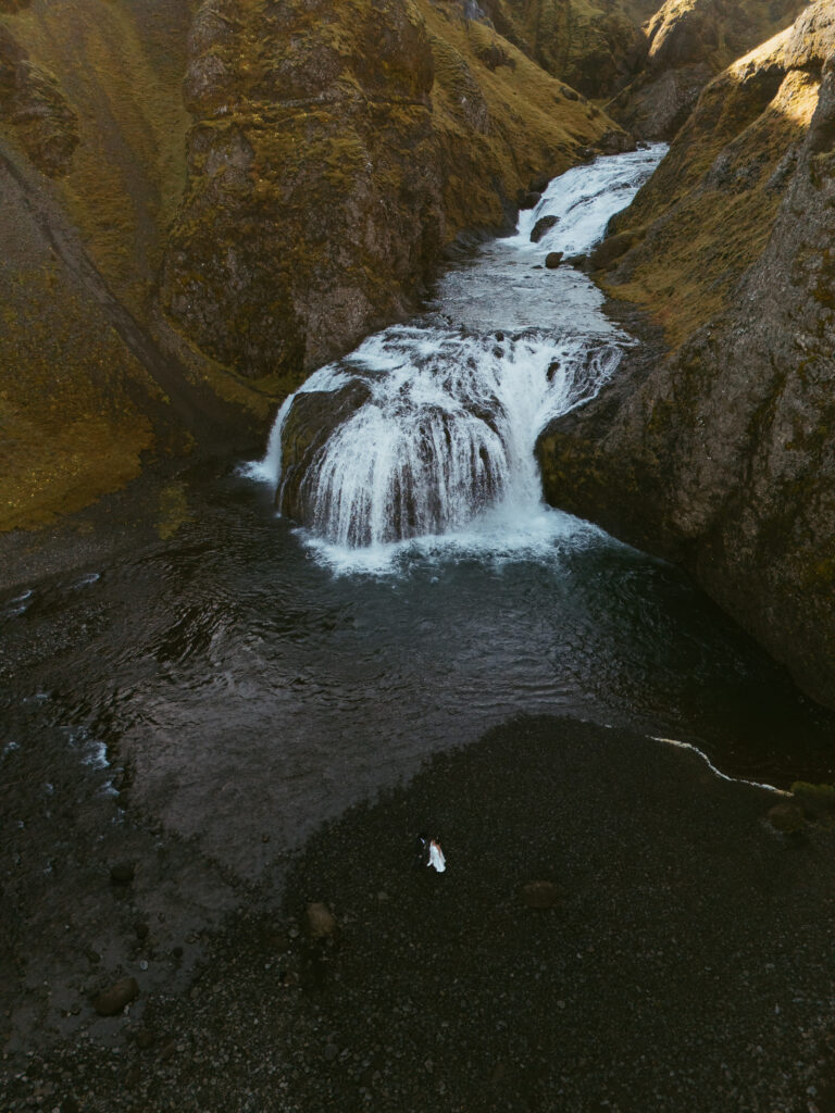 iceland elopement, couple standing in front of a waterfall