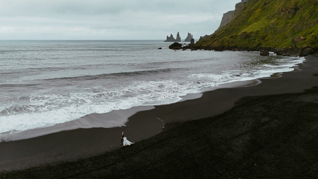 black sand beach drone photo of a couple eloping